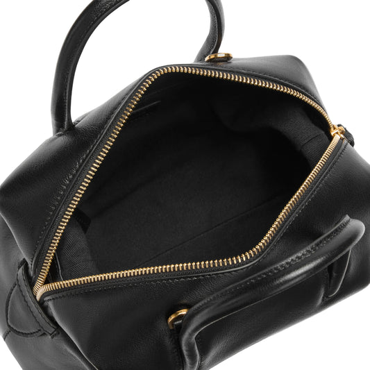 Black leather bag with gold zipper on a light background
