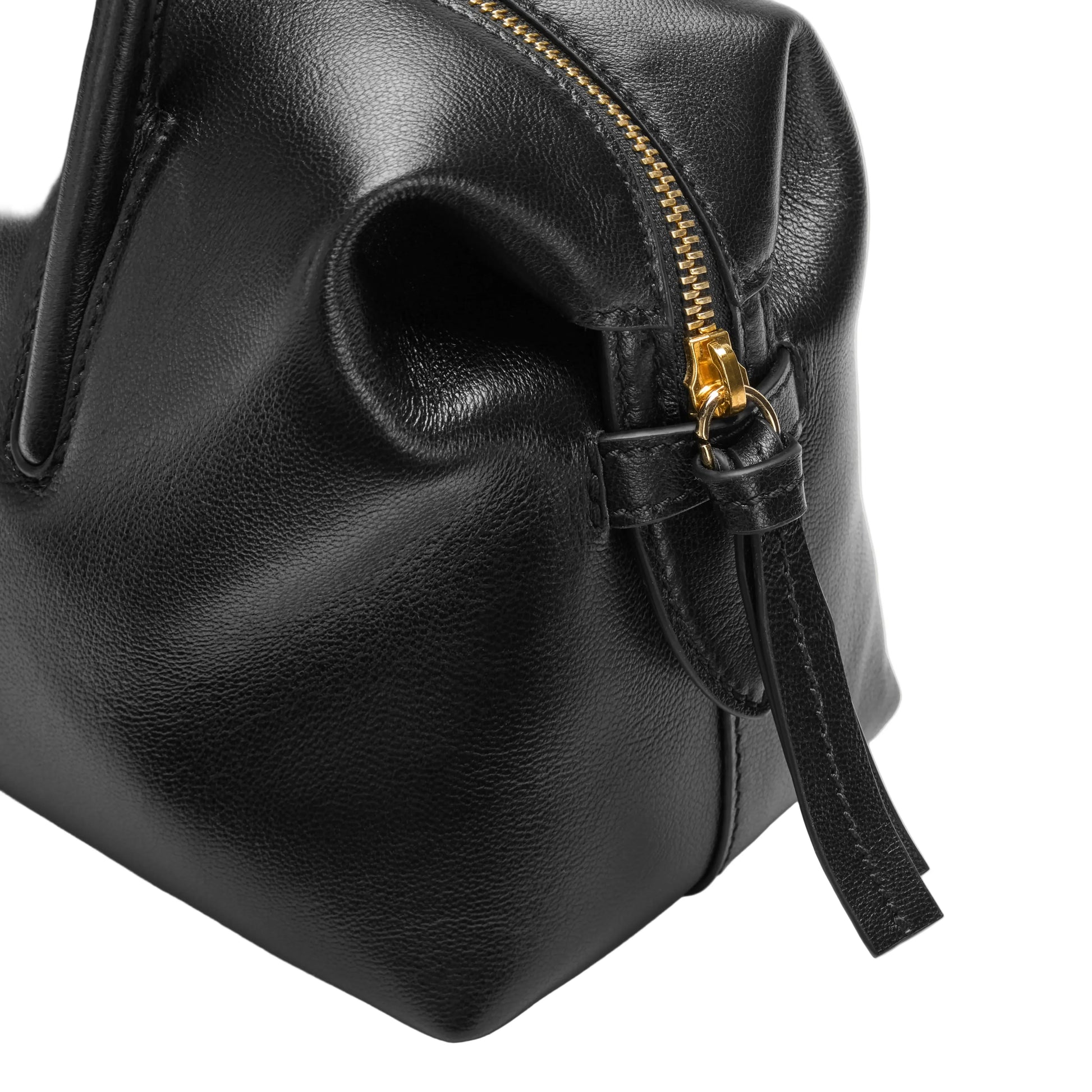 Black leather bag with a gold zipper on a light gray background