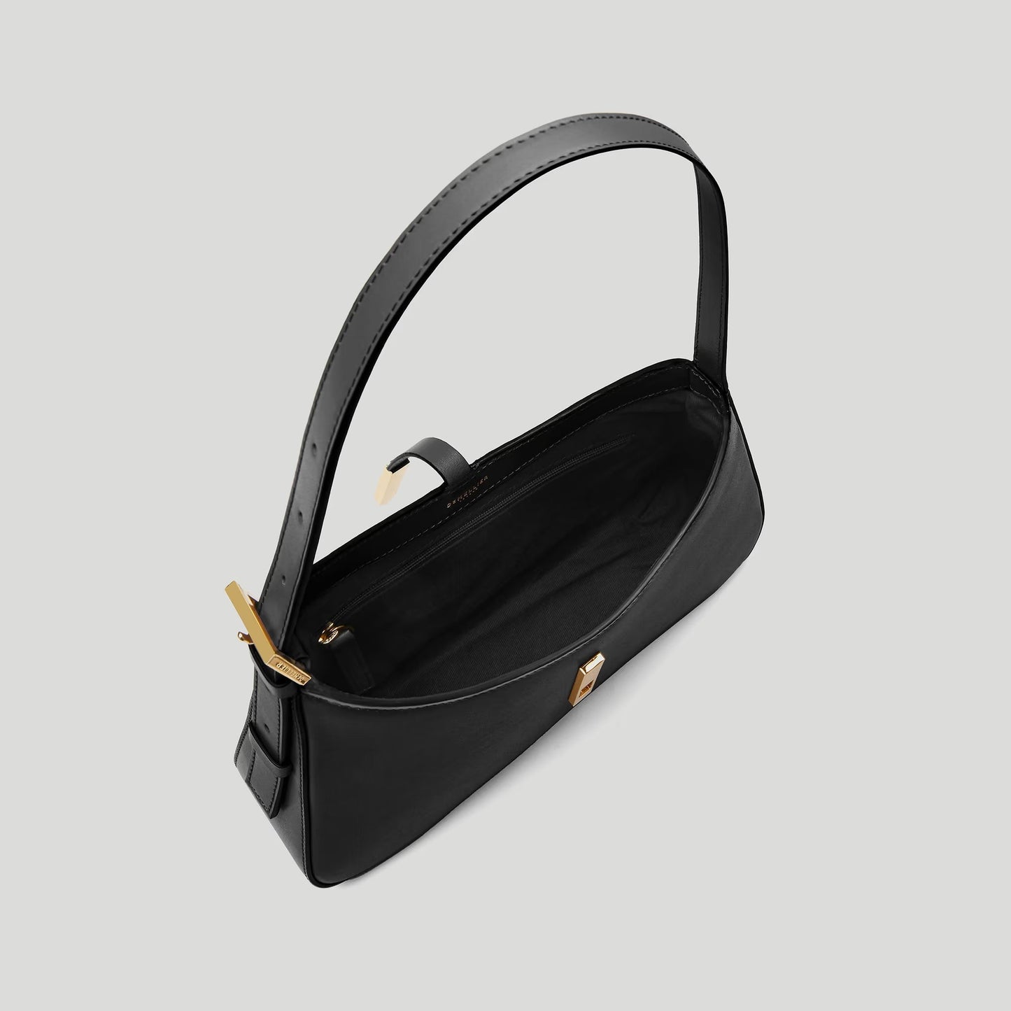 Black handbag with gold accents on a light gray background