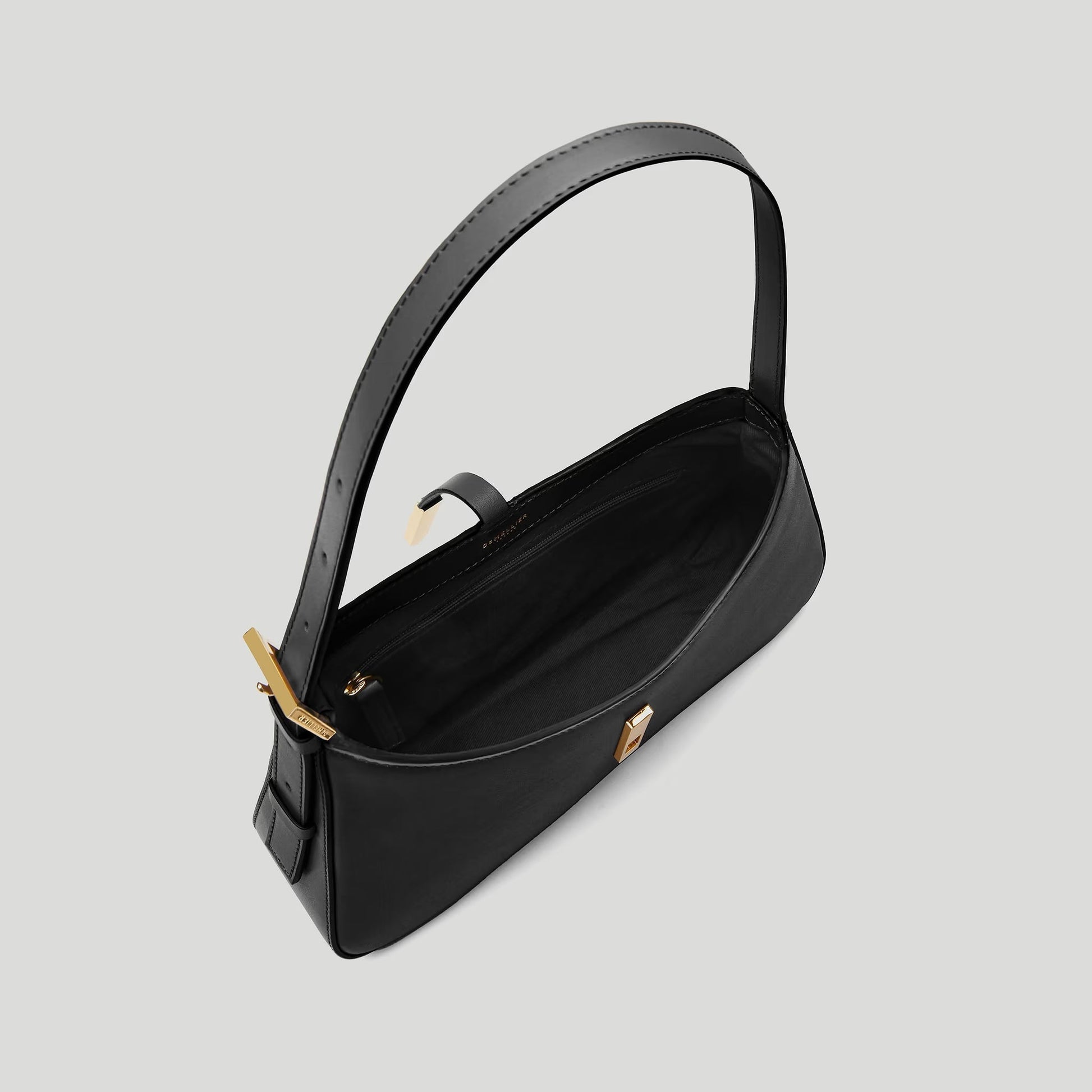Black handbag with gold accents on a light gray background
